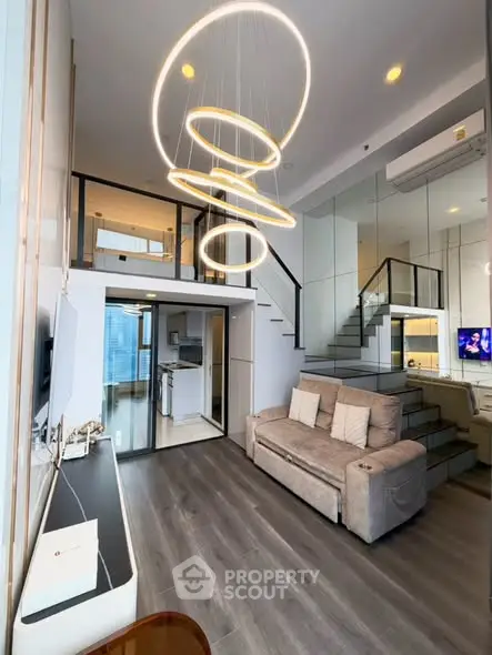 Modern duplex living room with stylish lighting and open kitchen layout