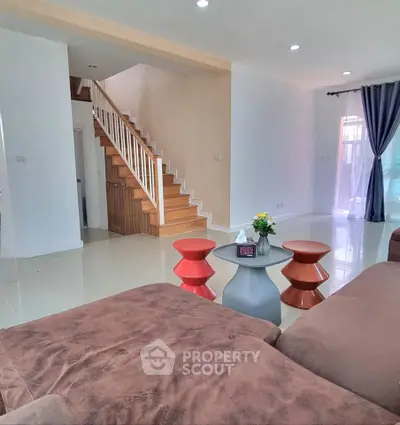 Spacious living room with modern staircase and stylish furniture