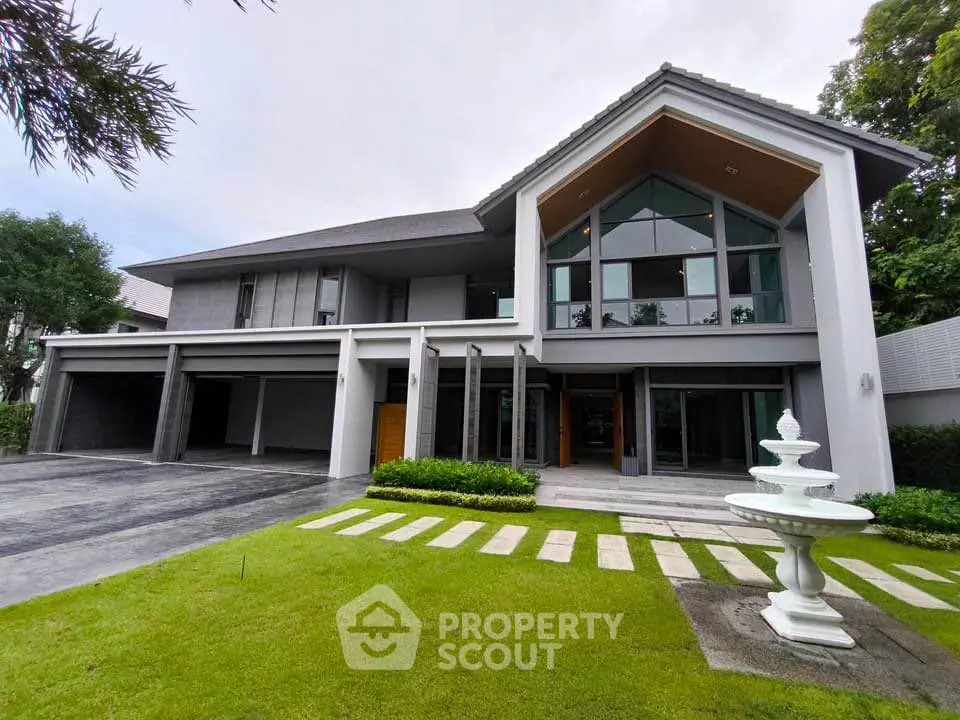 Stunning modern house with spacious driveway and lush green lawn, featuring elegant architectural design and large windows.