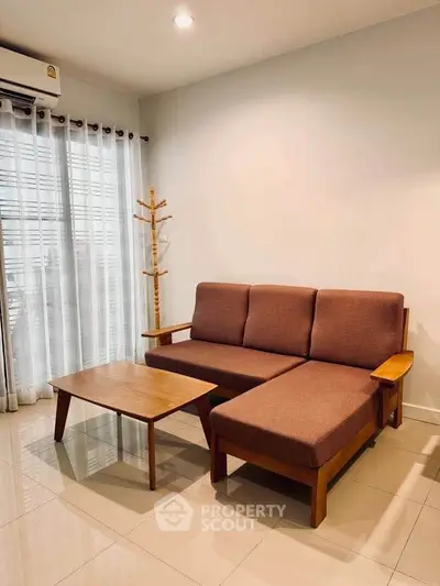 Cozy living room with modern brown sofa and wooden coffee table, perfect for relaxation.