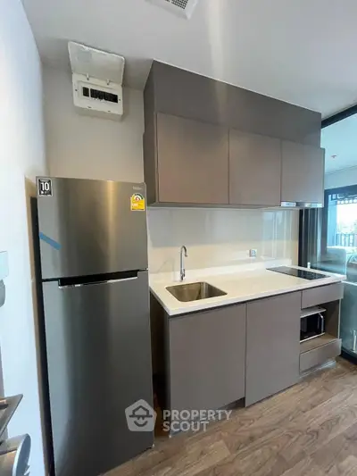Modern kitchen with sleek cabinetry and stainless steel appliances in a contemporary apartment.
