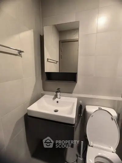 Modern bathroom with sleek sink and toilet in a minimalist design.