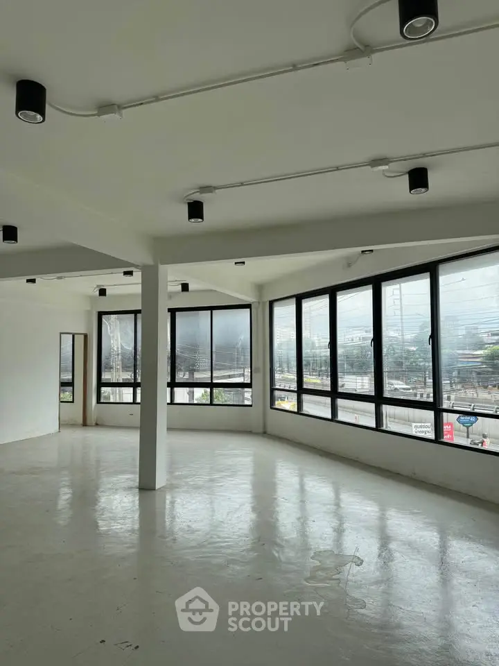 Spacious corner unit with large windows offering panoramic city views, ideal for modern living or office space.