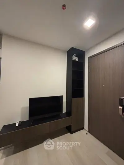 Modern minimalist living room with sleek TV unit and wooden door