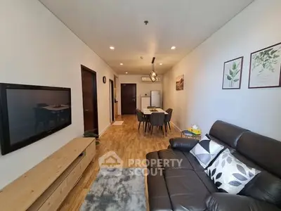 Modern living room with sleek leather sofa and wall-mounted TV in stylish apartment.