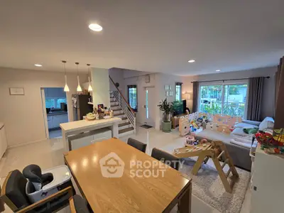 Spacious open-plan living room with modern decor and dining area, ideal for family gatherings.
