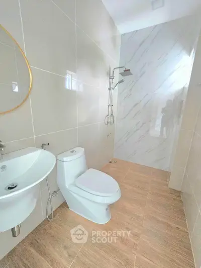 Modern bathroom with sleek design featuring a shower and elegant fixtures.