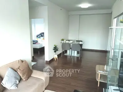 Modern living room with dining area and wooden flooring in a cozy apartment.