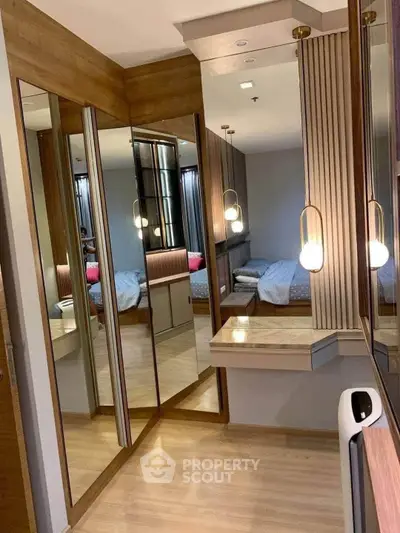 Luxurious bedroom with mirrored wardrobe and elegant lighting in modern apartment.