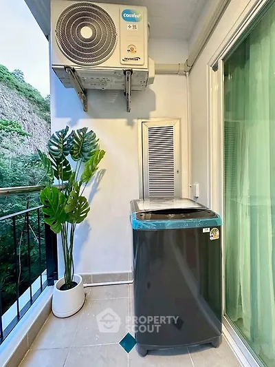 Modern balcony with washing machine and scenic view, perfect for urban living.