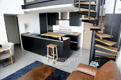 Modern loft apartment with sleek kitchen and spiral staircase