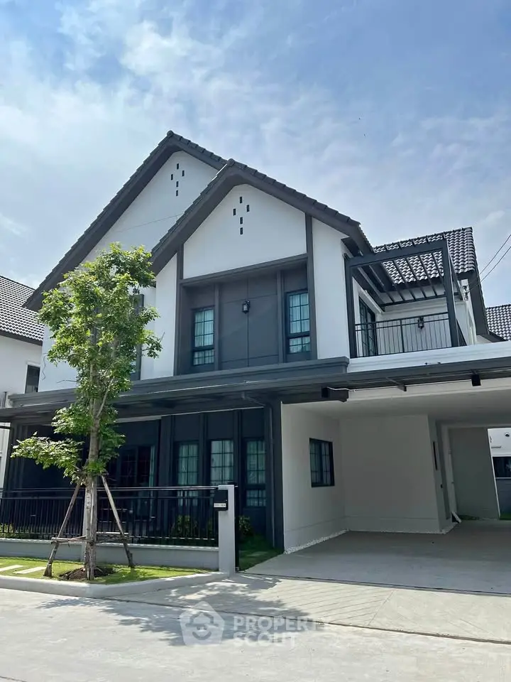 Modern two-story house with sleek design and spacious driveway in a serene neighborhood.