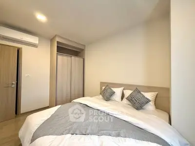 Modern bedroom with cozy bedding and sleek wardrobe in a stylish apartment.