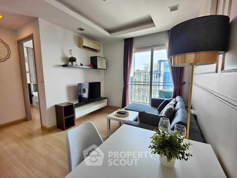 Modern living room with city view, stylish decor, and cozy seating area.
