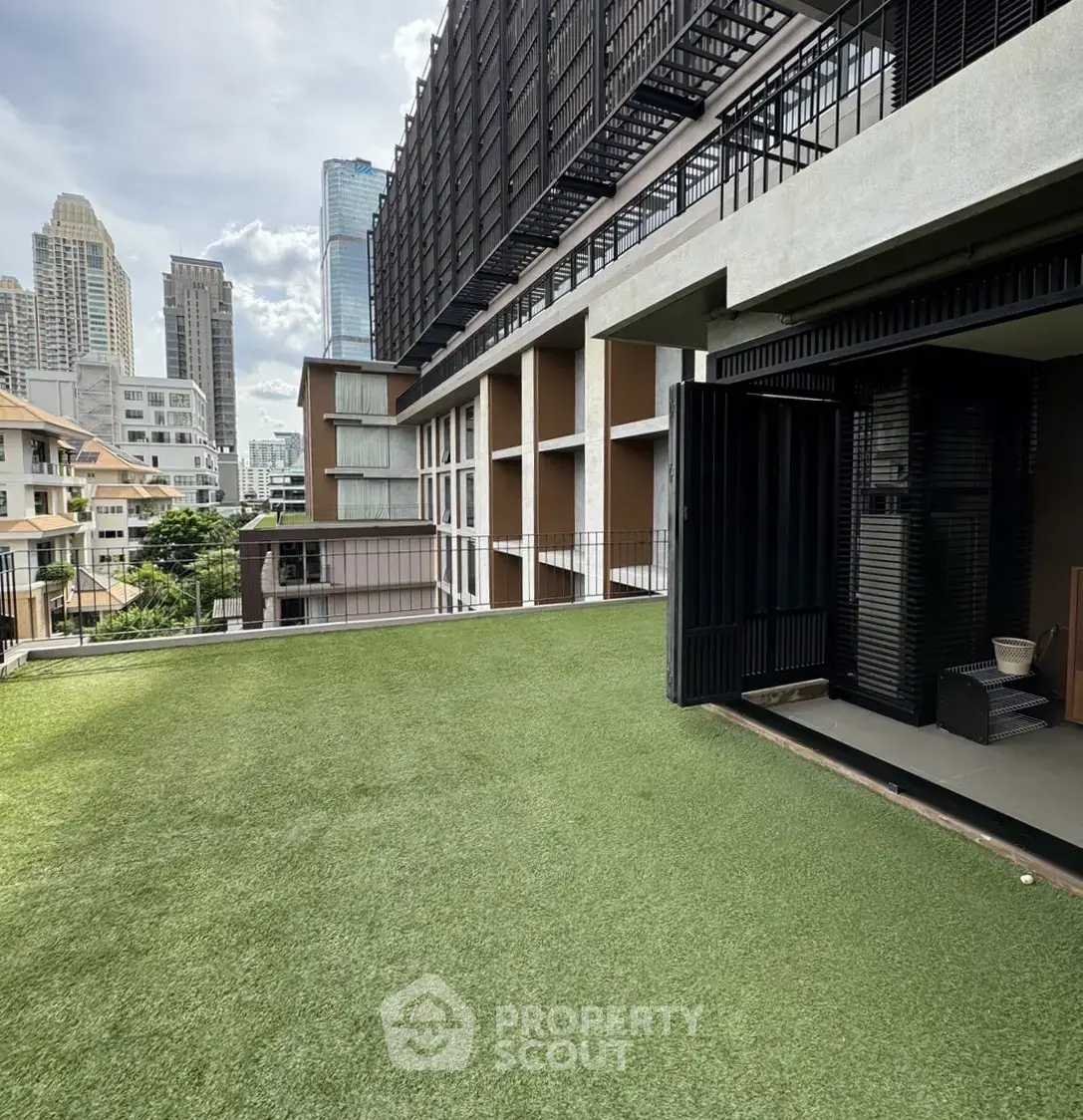 Modern urban building with rooftop garden and city skyline view.