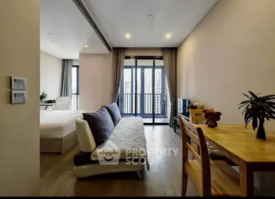 Modern studio apartment with open layout and balcony view in urban setting.