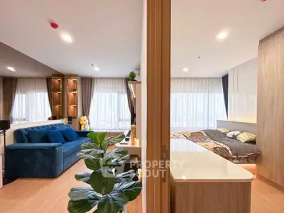 Modern open-plan living room and bedroom with stylish decor and natural light.