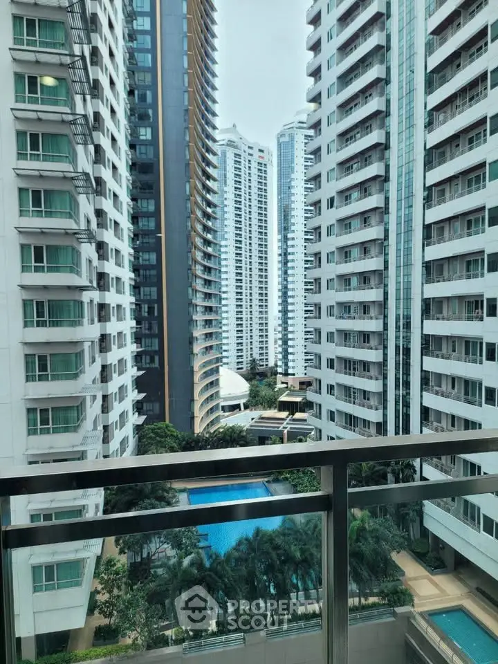 Stunning high-rise apartment view with pool and lush greenery, perfect for urban living.