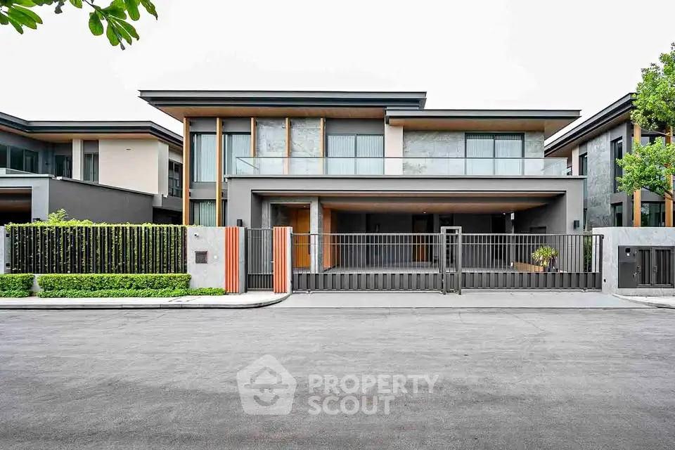 Modern luxury home with sleek design and spacious driveway in upscale neighborhood.