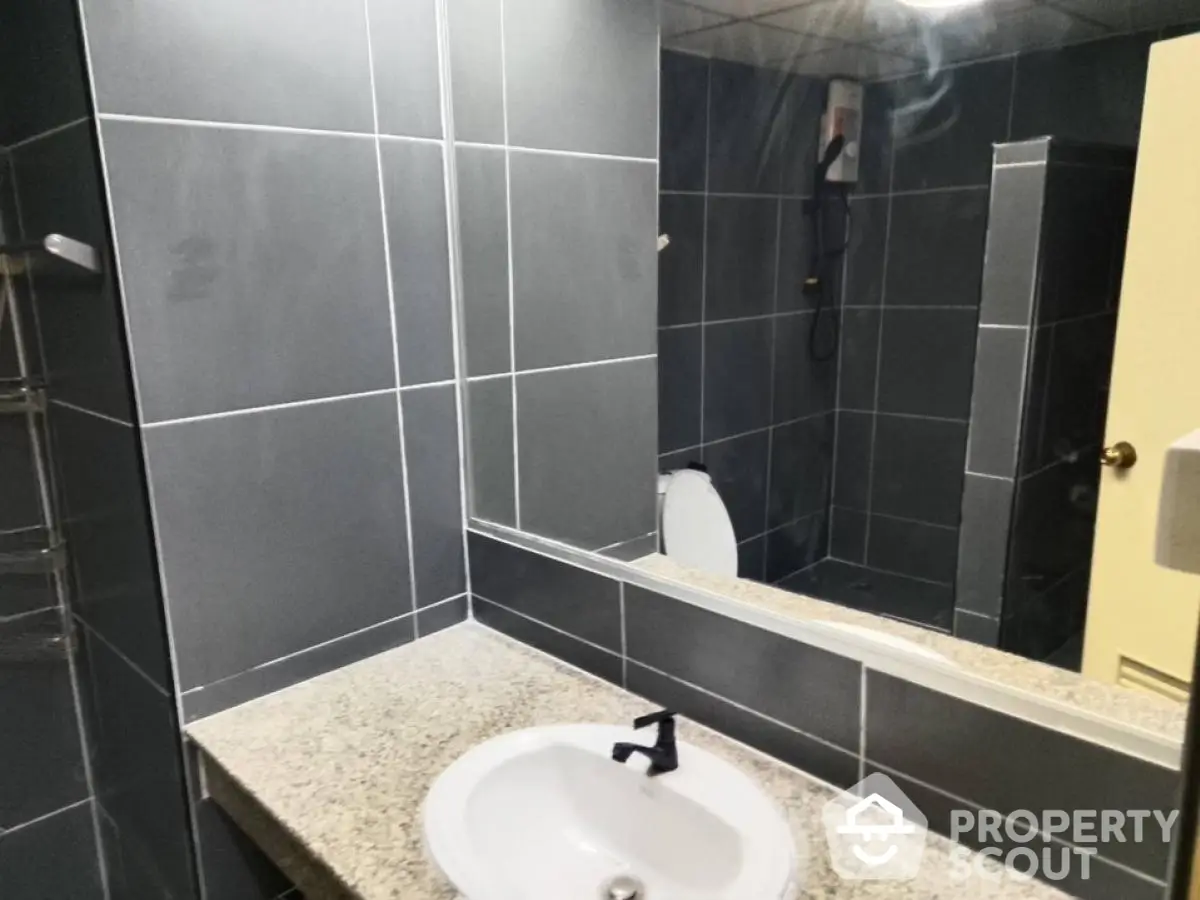 Modern bathroom with sleek dark tiles and stylish fixtures