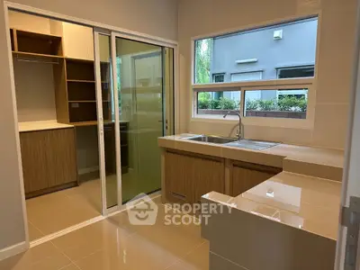 Modern kitchen with sleek cabinetry and large window for natural light