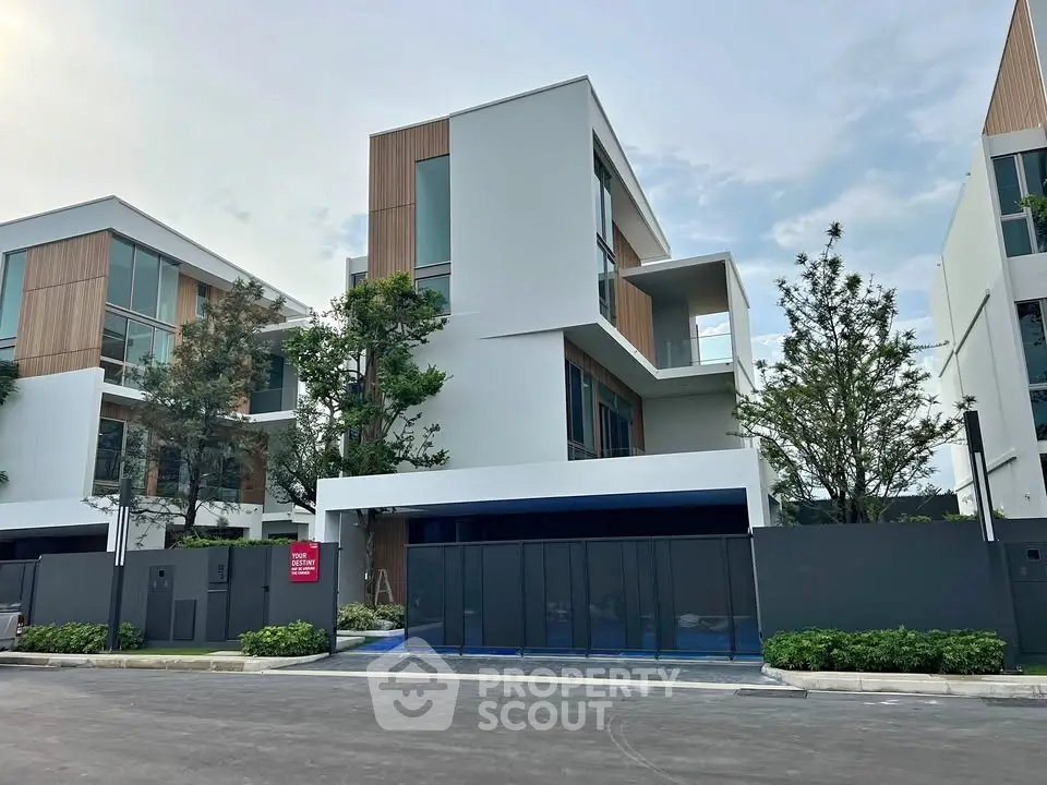 Modern multi-story house with sleek design and large windows in a serene neighborhood.