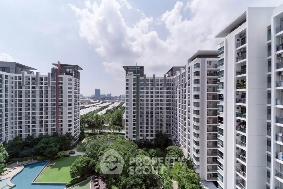 Modern high-rise residential buildings with lush gardens and swimming pool view.