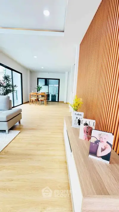 Spacious modern living room with wooden accents and large windows for natural light.