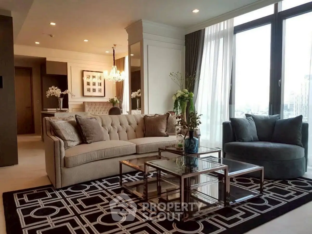 Luxurious living room with elegant decor and city view, featuring plush sofas and a stylish chandelier.
