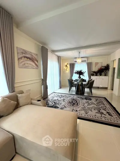 Elegant living room with modern decor and spacious layout, featuring a stylish dining area and large windows.