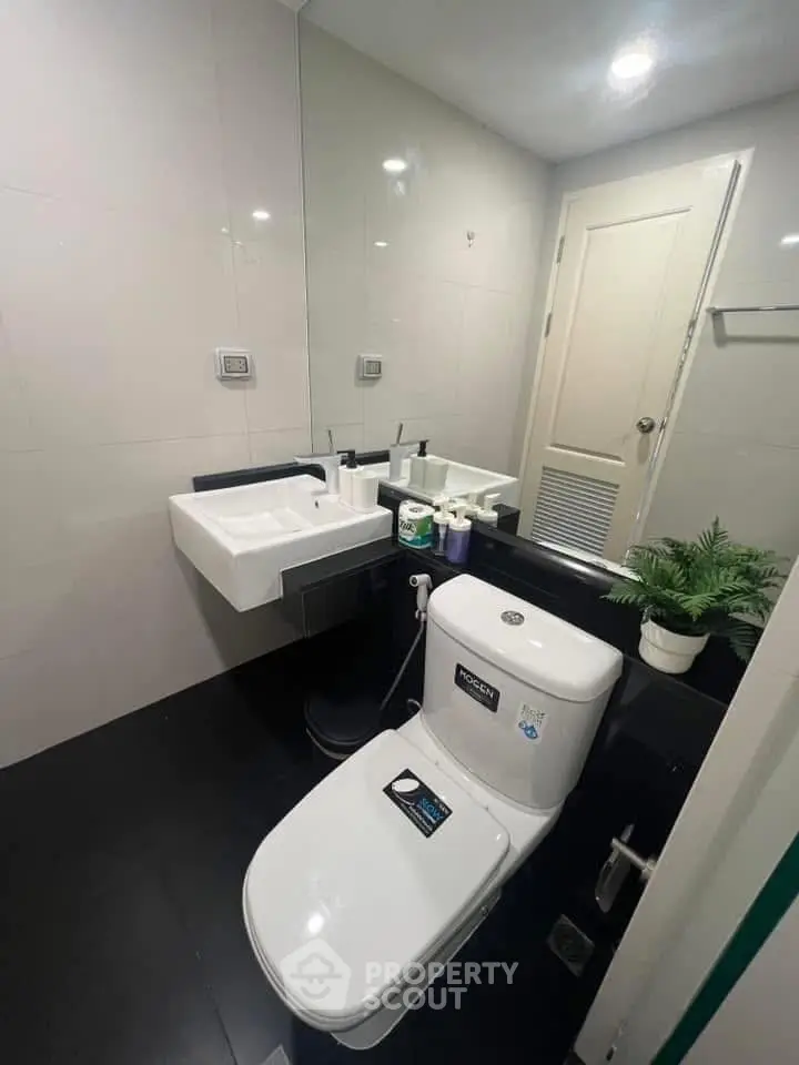 Modern bathroom with sleek fixtures and large mirror in a contemporary home.
