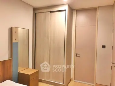 Modern bedroom with sleek wooden wardrobe and minimalist decor