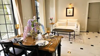 Elegant living room with dining area, featuring stylish decor and large windows for natural light.