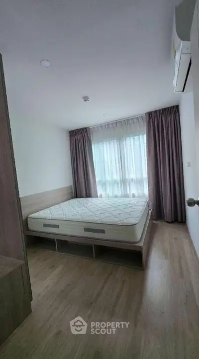 Cozy bedroom with natural light and modern furnishings in a stylish apartment.