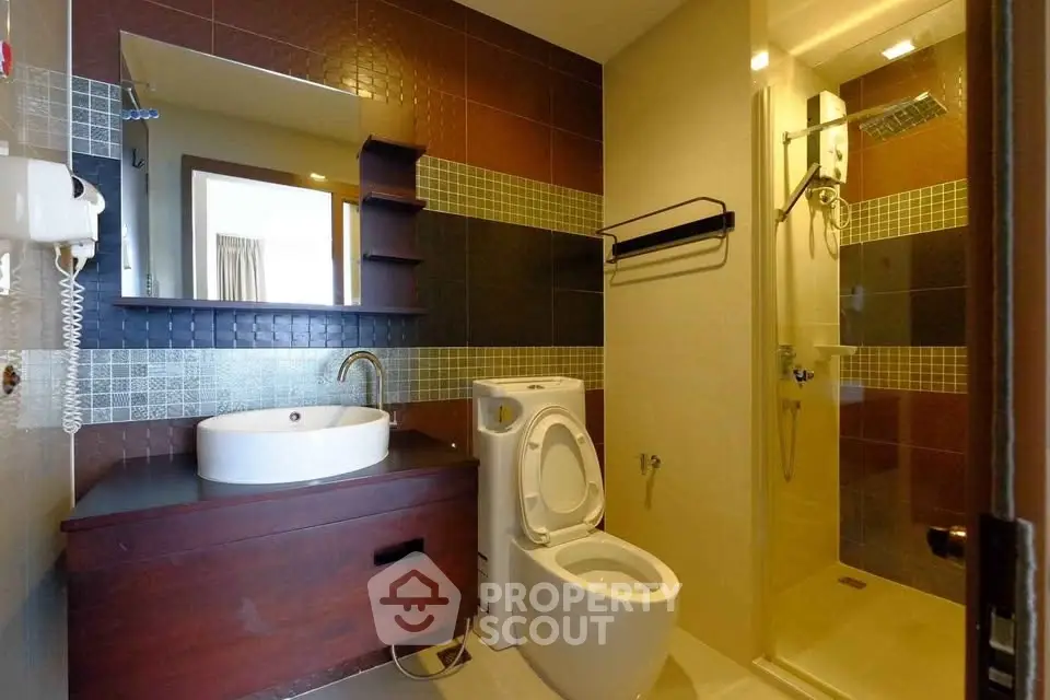 Modern bathroom with sleek design, featuring a glass shower and stylish vanity.