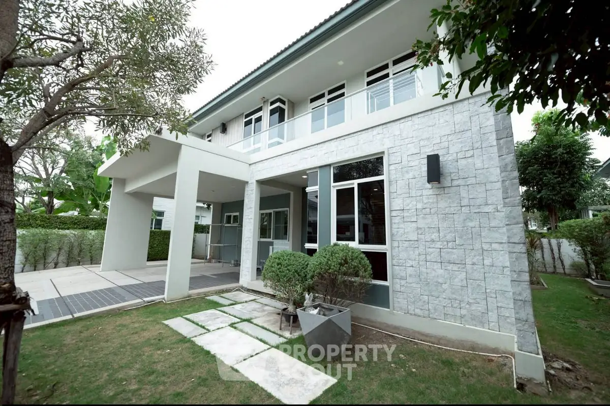 Modern two-story house with landscaped garden and stone facade