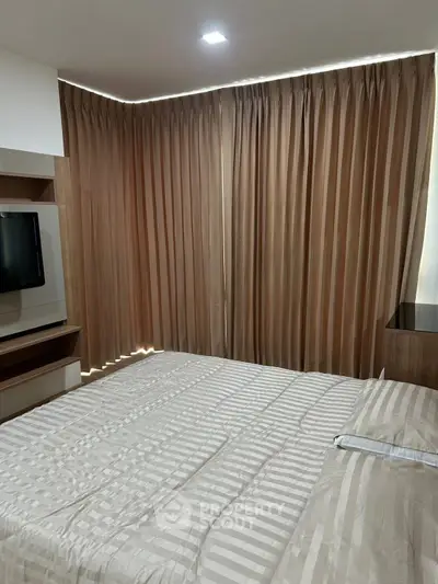 Cozy bedroom with modern decor and elegant curtains, perfect for relaxation and comfort.