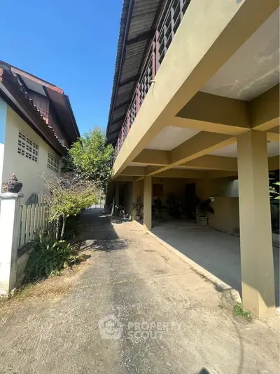 Spacious exterior view of a residential property with ample parking space and greenery.