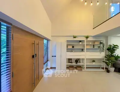 Spacious modern living room with high ceiling and stylish shelving