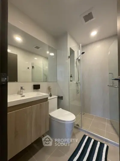 Modern bathroom with sleek shower and vanity in contemporary home.