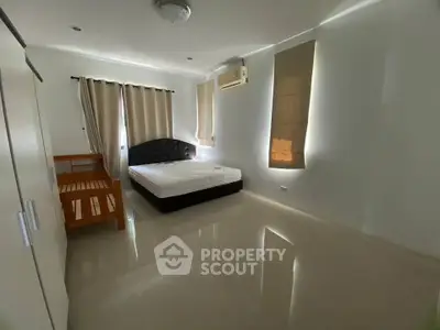 Spacious bedroom with modern furnishings and natural light