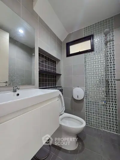 Modern bathroom with sleek design, featuring a shower and stylish tile work.