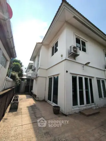 Charming two-story house with spacious outdoor patio and modern air conditioning units.