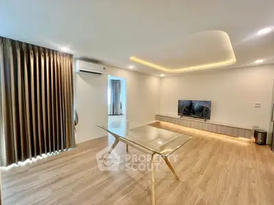 Spacious modern living room with elegant lighting and glass table