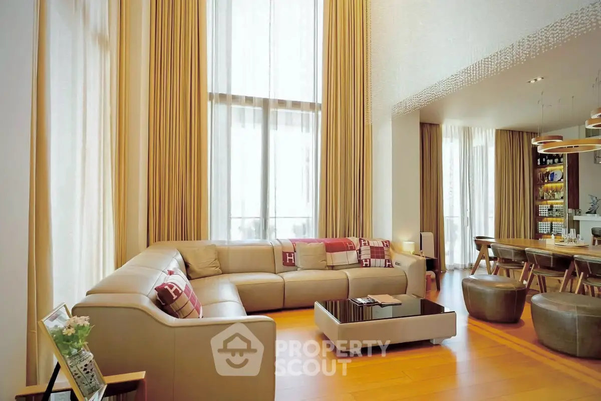 Luxurious high-ceiling living room with elegant decor and ample natural light