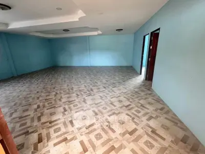 Spacious empty room with tiled flooring and blue walls, ideal for customization.