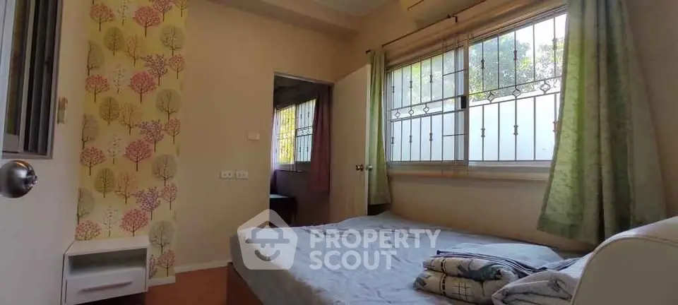 Cozy bedroom with large window and floral accent wall