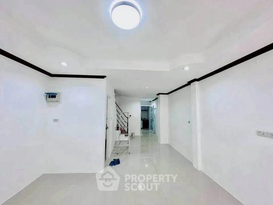 Spacious and bright interior with modern lighting and sleek tile flooring.