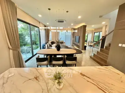 Luxurious open-plan living room with modern decor and large windows