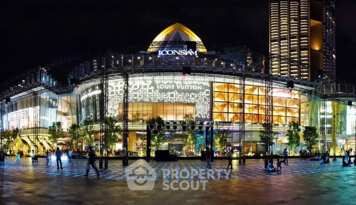 Stunning night view of Iconsiam shopping mall with illuminated facade and bustling atmosphere.